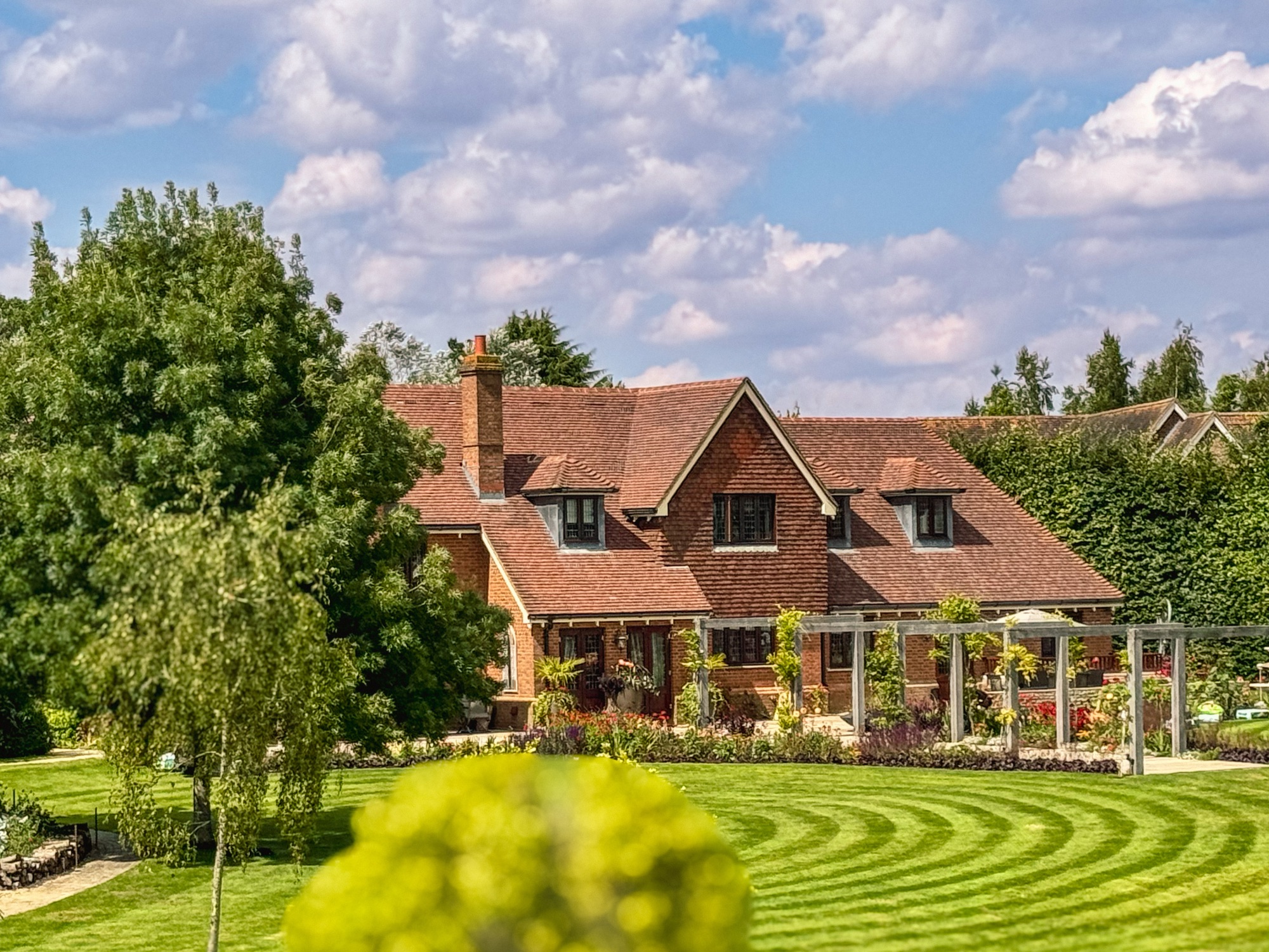 Country residence with manicured striped lawns in curved pattern